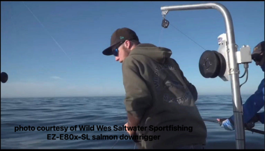 Person on a boat fishing with text about a EZ Puller salmon downrigger system.